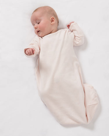 Newborn wearing organic cotton sleepsuit in pale pink – GOTS certified – fold over mittens and elasticated bottom – Babu
