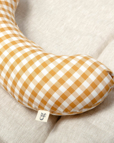 The Sonny Tummy Time support aid is a comfortable pillow that helps your baby in their early months. Sewn in a mustard check cotton fabric.