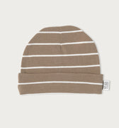 A knit beanie hat in a warm taupe-brown color with thin white horizontal stripes, featuring a folded cuff and a small white brand tag on the side, set against a solid off-white background.