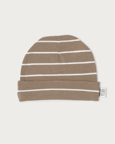 A knit beanie hat in a warm taupe-brown color with thin white horizontal stripes, featuring a folded cuff and a small white brand tag on the side, set against a solid off-white background.