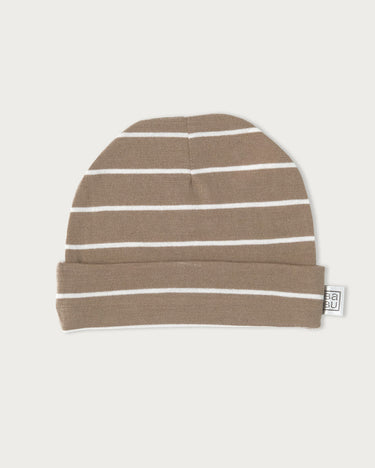 A knit beanie hat in a warm taupe-brown color with thin white horizontal stripes, featuring a folded cuff and a small white brand tag on the side, set against a solid off-white background.